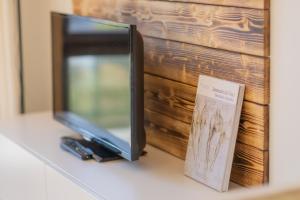 a television sitting on a counter next to a book at ABA Apartamenty Comfort Family in Krynica Zdrój