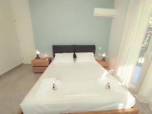 una camera da letto con un grande letto bianco con due candele di Casa Elegante a Potamós