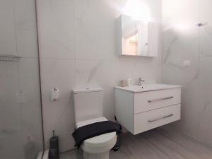 bagno bianco con servizi igienici e lavandino di Casa Elegante a Potamós