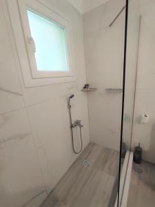bagno con doccia e finestra di Casa Elegante a Potamós