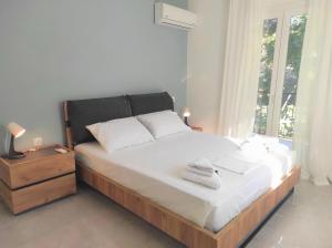 una camera da letto con un grande letto con lenzuola bianche e una finestra di Casa Elegante a Potamós
