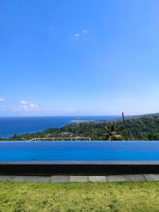 a blue swimming pool with the ocean in the background at Villa Aryaguna in Senggigi 