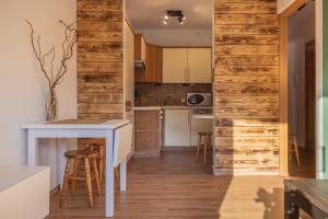 a kitchen with wooden walls and a table and chairs at ABA Apartamenty Comfort Family in Krynica Zdrój