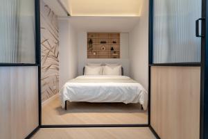 - une chambre avec un lit blanc et un miroir dans l'établissement North by Urbanesq Cortina D, à Voluntari