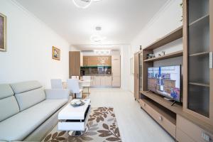 - un salon avec un canapé et une télévision dans l'établissement Grand Karavel Top Center Lux Apartment, à Varna