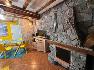 a kitchen with a stone fireplace and a table and chairs at Casa da Nogueira in Porto Moniz