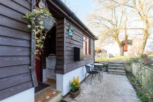 a tiny house with a patio and a table at Dairy Cottage in Roffey