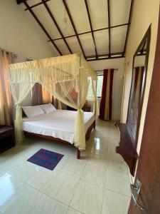 a bedroom with a bed with a canopy at Elegant Hotel in Bandarawela