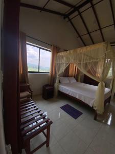 a bedroom with a canopy bed and a large window at Elegant Hotel in Bandarawela