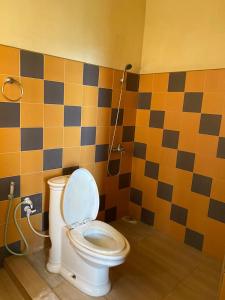 a bathroom with a toilet and a shower at Elegant Hotel in Bandarawela
