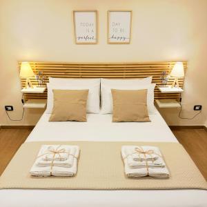 - une chambre avec un lit blanc et des serviettes dans l'établissement Casetta 26, à Naples