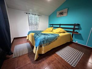 a bedroom with a bed and a blue wall at Casa da Nogueira in Porto Moniz