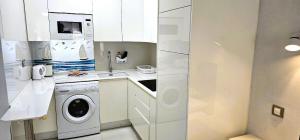 une cuisine blanche avec un lave-linge et un lave-linge dans l'établissement Apartment in Paraiso Royal, à Playa de las Americas