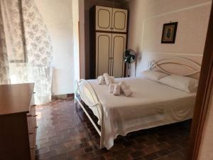 Un dormitorio con una cama blanca con toallas. en Casa di Adele, en Anzio