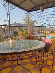 d'une terrasse avec une table et des chaises sur un balcon. dans l'établissement Riad lala Drissia, à Fès