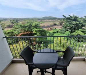 a table and chairs on a balcony with a view at Aastha Escape Resort near Calangute Beach in Calangute