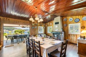 uma sala de jantar com uma mesa e cadeiras e paredes de madeira em Sé Apartamentos - Chalé da Caniçada em Rio Caldo