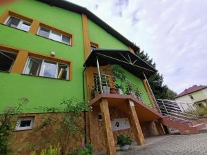 a green house with a staircase in front of it at Apartamenty Zdrowa 6 in Ciężkowice +14 photos