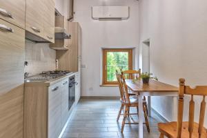 Una cocina con una mesa de madera y un comedor. en Il Piccolo Podere, en Foiano della Chiana