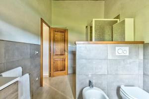 Un baño con inodoro, lavabo y espejo. en Il Piccolo Podere, en Foiano della Chiana