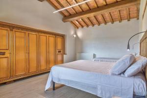 1 dormitorio con 1 cama y armarios de madera en Il Piccolo Podere, en Foiano della Chiana