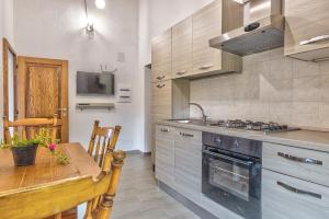 una cocina con una mesa y una estufa horno superior en Il Piccolo Podere, en Foiano della Chiana 32 fotos más
