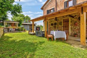 una casa de piedra con una mesa en el patio en Il Piccolo Podere, en Foiano della Chiana