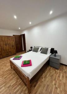 1 dormitorio con 1 cama grande y 2 toallas. en Hotel Kenito Apartamentos T1 To T3, en São Tomé
