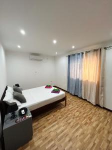 ein Schlafzimmer mit einem großen Bett und Holzboden in der Unterkunft Hotel Kenito Apartamentos T1 To T3 in São Tomé