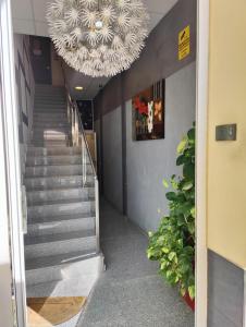 una escalera con una gran lámpara de araña en un edificio en Hostal Manel, en Pineda de Mar