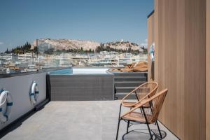 une chaise assise sur un balcon avec piscine dans l'établissement The Edge - Luxury Residences, à Athènes