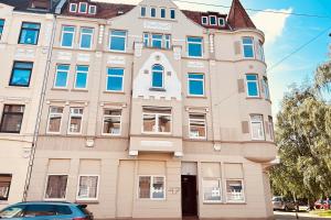 a building with a car parked in front of it at Work & Stay Apartment with Balcony in Bremerhaven in Bremerhaven