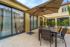 第戎的住宿－Maison calme avec terrasse/garage centre-ville C，庭院内桌椅和遮阳伞