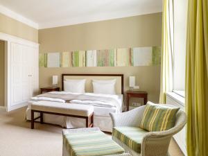 ein Schlafzimmer mit einem Bett, einer Couch und einem Sessel in der Unterkunft A-ROSA Travemünde in Travemünde + 37 Fotos