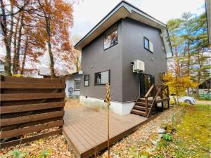 a gray house with a wooden deck in front of it at Bond Chalet Hakuba - Vacation STAY 76698v in Hakuba