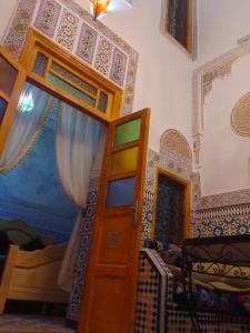 Habitación con litera y puerta. en Riad lala Drissia, en Fez
