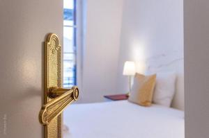 a gold doorhandle to a bedroom with a bed at Les toits de Bailly Disney Paris in Bailly-Romainvilliers