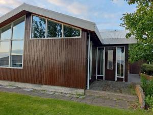uma casa com uma fachada de madeira com portas de vidro em Budanes 1 em Stykkishólmur