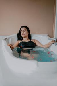 a woman is sitting in a bath tub at Kuruva Island Resort And Spa - By KABINI BREEZE, Wayanad in Mananthavady