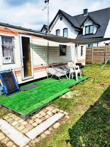 a yard with a green lawn in front of a house at Dworek Łeba in Łeba