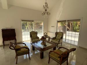 Una sala de estar con sillas, una mesa y un piano. en Villa Sawa by Ezoria Villas, en Limassol