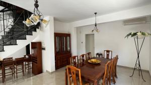 Un comedor con mesa y sillas y una escalera. en Villa Sawa by Ezoria Villas, en Limassol