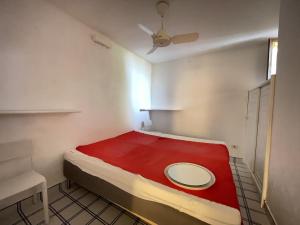 um pequeno quarto com uma cama com um cobertor vermelho em Villa Pellicano em Villasimius