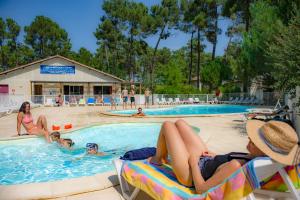 um grupo de pessoas na piscina de um resort em Résidence Goélia Les Demeures du Lac em Casteljaloux
