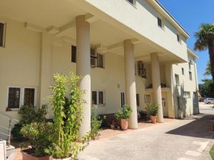 een gebouw met zuilen en planten ervoor bij Guest House Andre in Međugorje