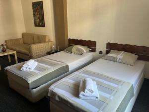 Habitación de hotel con 2 camas y sofá en Vel House en Plovdiv