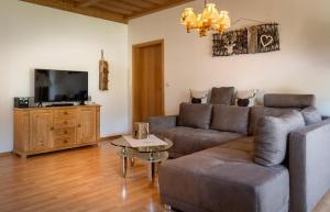 a living room with a couch and a flat screen tv at Landhaus Laih in Grafenau