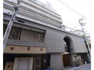 a brick building with a tall building in the background at Alphabed Takamatsu Furujinmachi - Vacation STAY 11906 in Takamatsu