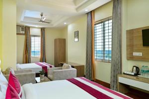 范兰德凡Hotel SKS Grand Palace-Vrindāvan的有两张床和一台电视的酒店房间
