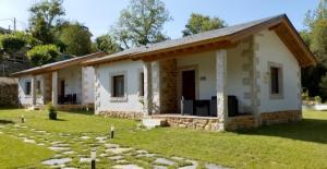 una pequeña casa blanca con un patio de césped en Lagunas de Sanabria, en Trefacio